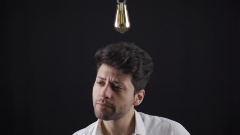 Clever-man-comes-up-with-an-idea,-a-symbolic-idea-lamp-lights-up-above-his-head.